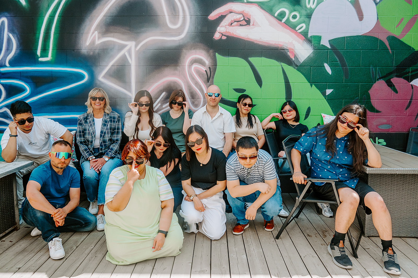 Kickbyte team posing in sunglasses in front of a colourful outdoor mural.